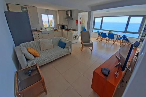 ein Wohnzimmer mit einer Couch und einem Tisch mit Stühlen in der Unterkunft Yellow House in Jardim do Mar