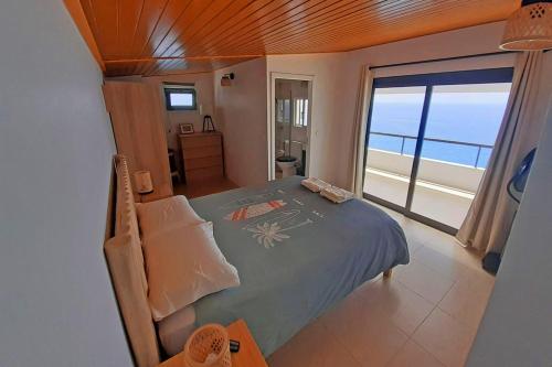 ein Schlafzimmer mit einem Bett mit Blick auf das Meer in der Unterkunft Yellow House in Jardim do Mar