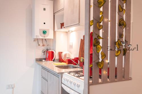 a kitchen with white cabinets and a stove top oven at EmBruHadas Yellow in San Salvador de Jujuy