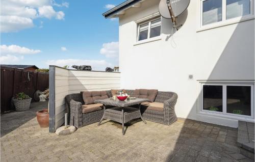 a patio with two wicker chairs and a table at Awesome Home In Hvide Sande With Wifi in Hvide Sande
