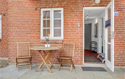 a table and two chairs in front of a brick building at Amazing Home In Rømø With Kitchen in Havneby
