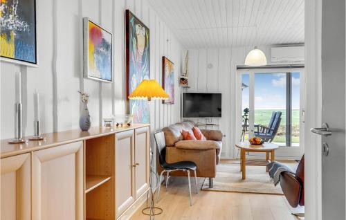a living room with a couch a chair and a tv at Amazing Home In Rømø With Kitchen in Havneby