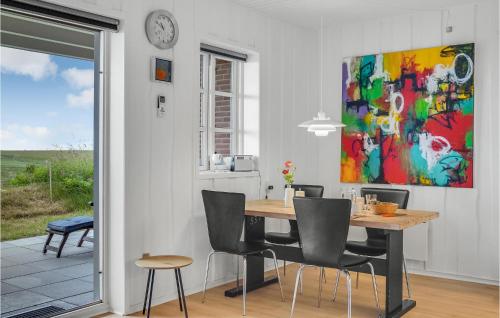 a dining room with a table and a painting on the wall at Amazing Home In Rømø With Kitchen in Havneby