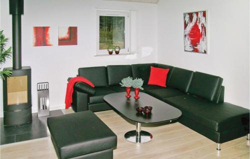 a living room with a green couch and a table at Holiday Home Skørbækshave Sindal Denm in Tolne