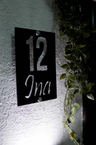 a black sign with the number on a wall at Apartman Ina stan na dan in Donje Mladice