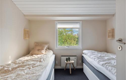 two beds in a small room with a window at Nice Home In Juelsminde With Kitchen in Juelsminde