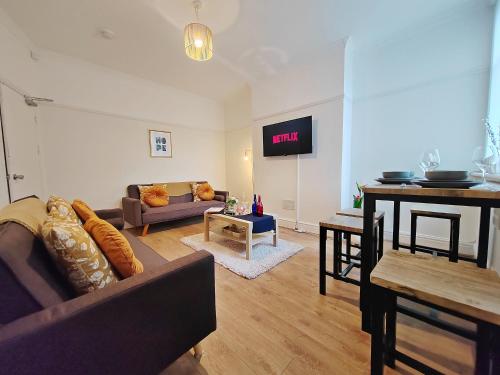 a living room with a couch and a table at Central Manchester Modern 4 Bed House - free parking in Manchester