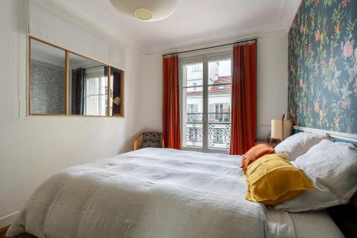 une chambre avec un grand lit et une fenêtre dans l'établissement Appartement charmant à Paris 31 m² avec équipements modernes, à Paris