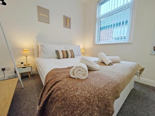 a bedroom with two beds with white sheets and a window at Central Manchester Modern 4 Bed House - free parking in Manchester