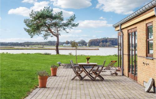 a patio with a table and chairs and a tree at Cozy Home In Malling With Wifi in Malling