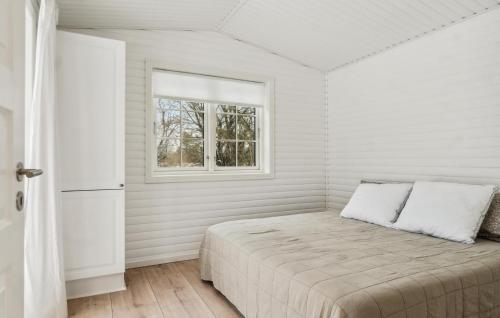 a white bedroom with a bed and a window at Cozy Home In Liseleje With Sauna in Liseleje
