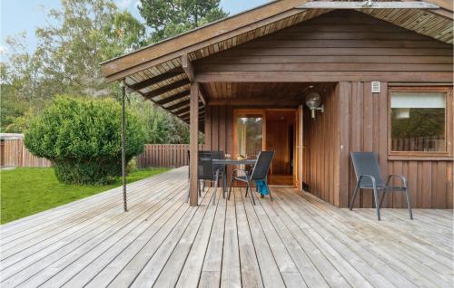 a wooden deck with a table and chairs on it at Stunning Home In Vejby With Kitchen in Vejby