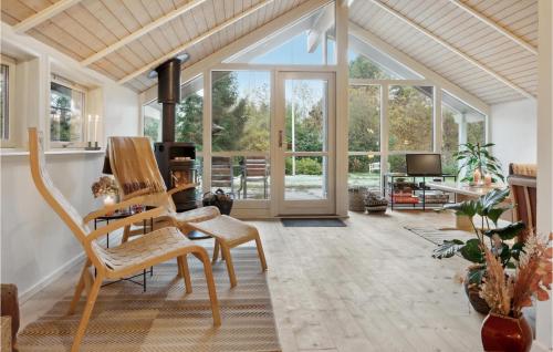 a living room with rocking chairs and a large window at 4 Bedroom Beautiful Home In Melby in Melby