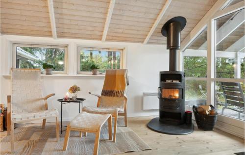 a living room with a wood stove and chairs at 4 Bedroom Beautiful Home In Melby in Melby