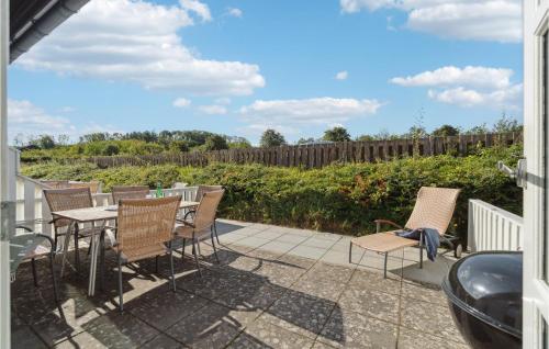 a patio with chairs and tables and a fence at Awesome Apartment In Allinge With Wifi in Allinge