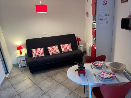 un salon avec un canapé noir et une table dans l'établissement pTIT HUGO, à Saint-Nectaire