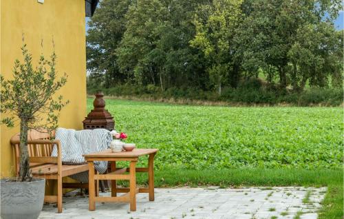 a patio with a table and a chair and a field at Lovely Home In Rudkøbing With Wifi in Rudkøbing