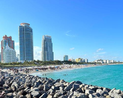 a beach with people in the water and buildings at South of Fifth Studio Steps to Beach on Ocean Drive in Miami Beach