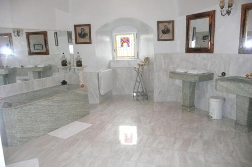 ein Badezimmer mit zwei Waschbecken, einer Badewanne und einem WC in der Unterkunft Château De Saint-Maixant in Saint-Maixant