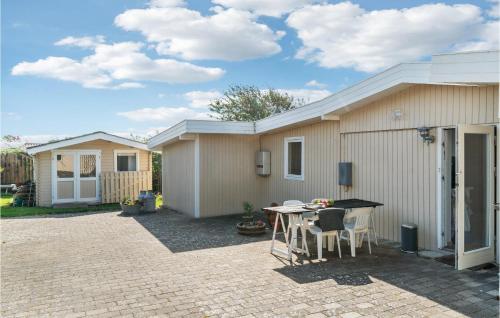 eine Terrasse mit Tisch und Stühlen vor einem Haus in der Unterkunft 2 Bedroom Awesome Home In Kalundborg in Kalundborg