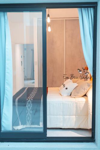 a glass window with a bed in a room at EmBruHadas Yellow in San Salvador de Jujuy