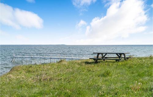 a picnic table sitting on the side of the ocean at Nice Home In Kalundborg With Wifi in Kalundborg