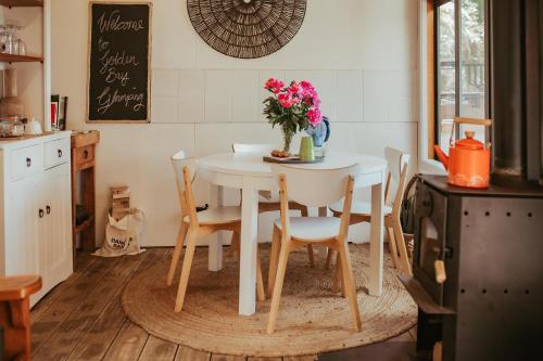 a kitchen with a table with a vase of flowers on it at Golden Bay Glamping in Takaka