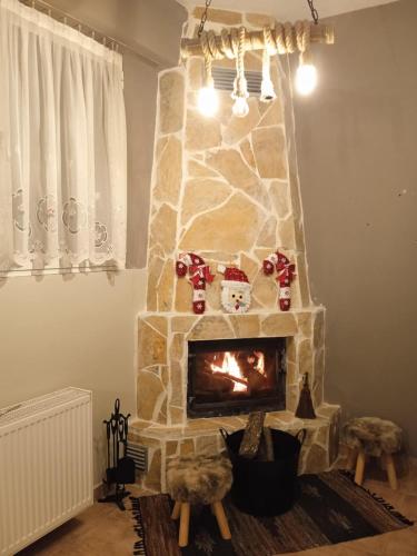 a living room with a stone fireplace with christmas decorations at Chrysoula's home -koziakas- PYLI in Pýli