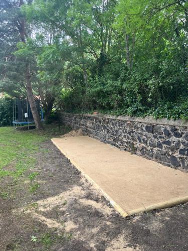 un mur de retenue en pierre et une rampe en bois à côté d'un trottoir dans l'établissement La Claudette, à Saurier