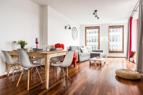 ein Wohnzimmer mit einem Tisch, Stühlen und einem Sofa in der Unterkunft Glob Apartament Sea Towers Gdynia in Gdynia