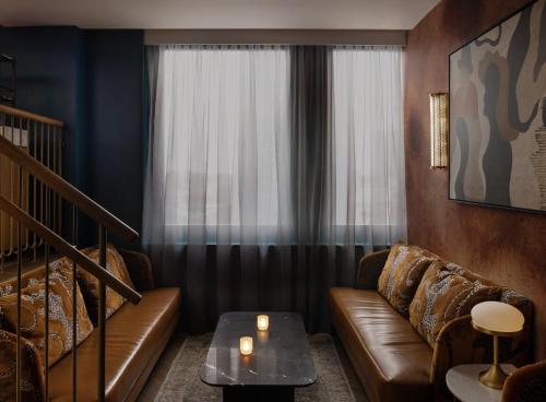 a living room with a couch and a window at Kimpton Theta New York - Times Square by IHG in New York