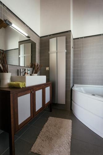 a bathroom with two sinks and a tub and a mirror at Dream Summer Villa in Porto Heli