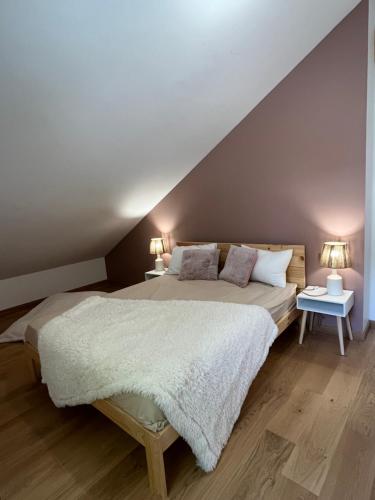 une chambre avec un grand lit et deux lampes dans l'établissement le petit ours, à Orcières