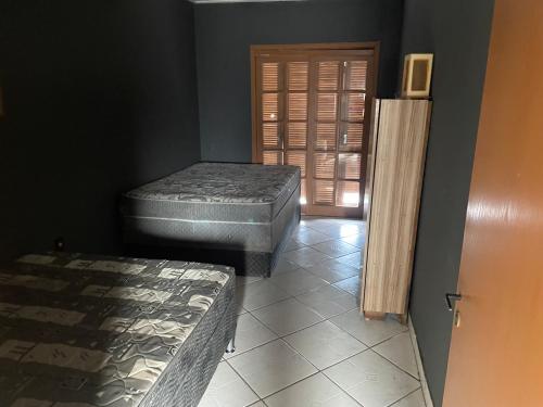 una camera con due materassi e una porta per una stanza di Casa com piscina Tramandai a Tramandaí