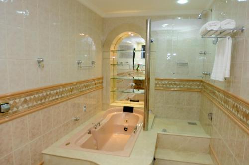 a large bathroom with a tub and a shower at Mavil Plaza Hotel in Paragominas