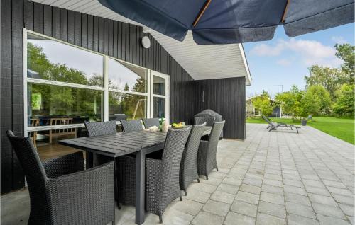 a patio with a table and chairs and an umbrella at Holiday Home Filosofstræde Vi in Dannemare