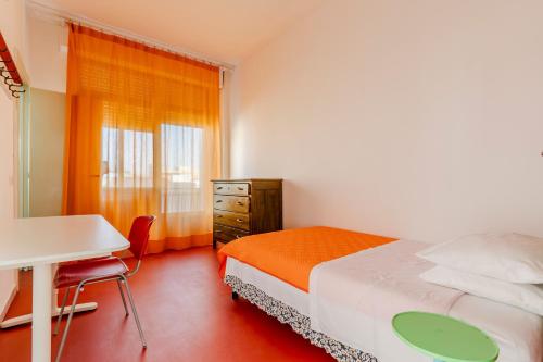 una camera da letto con un letto, una scrivania e una finestra di Casa di Madre Antonia a Brindisi