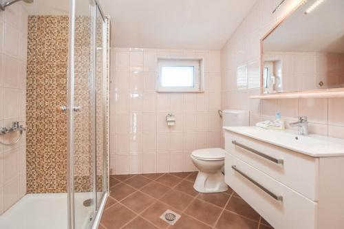 ein Badezimmer mit Dusche, Toilette und Waschbecken in der Unterkunft Apartments Svarog in Biograd na Moru