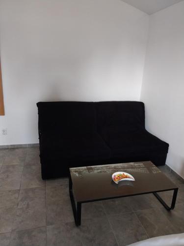 a black couch with a table in a living room at LIBERO APARTMANI in Surčin