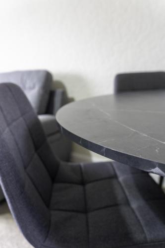 a table and a black chair and a couch at Raploch House in Larkhall