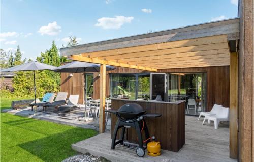 a backyard patio with an outdoor bar with an umbrella at Beautiful Home In Sjællands Odde in Yderby