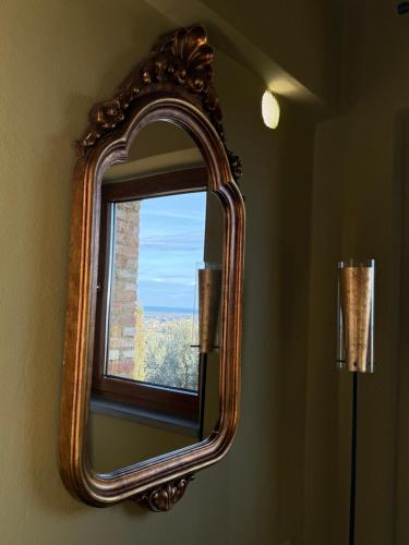 a mirror hanging on a wall with a window at Sacro e Profano Albania in Zikxhafaj