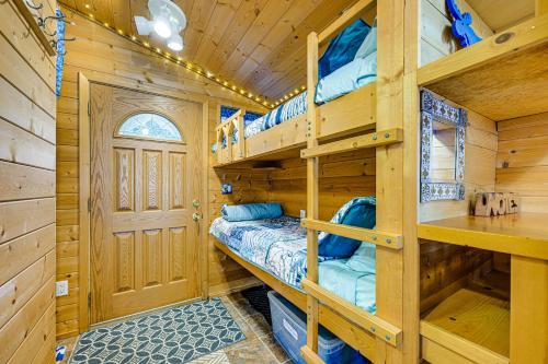 a log cabin bedroom with bunk beds and a door at Deck and Panoramic Views Bayfront House in Homer! in Homer