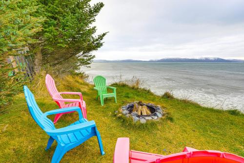 four chairs sitting around a fire pit next to the water at Deck and Panoramic Views Bayfront House in Homer! in Homer