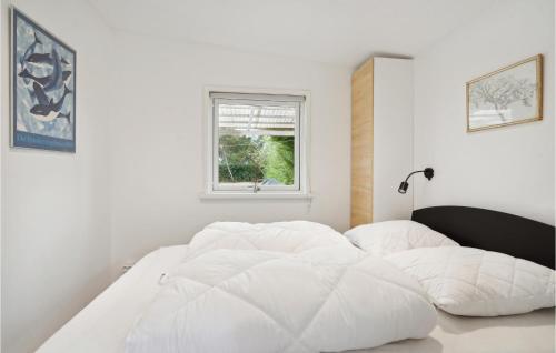 a white bed in a white room with a window at 5 Bedroom Nice Home In Asperup in Asperup