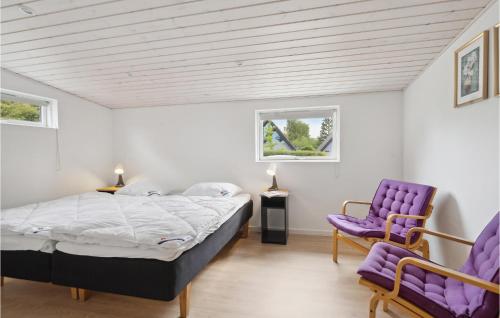 a bedroom with a bed and two purple chairs at 5 Bedroom Nice Home In Asperup in Asperup