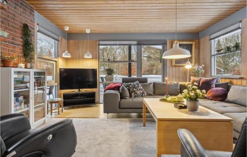 a living room with a couch and a table at Holiday Home Bøsholmstien Glesborg Denm in Fjellerup Strand