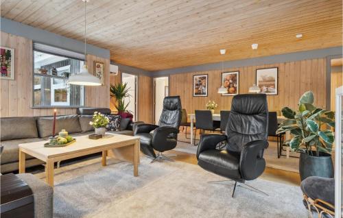 a living room with chairs and a table at Holiday Home Bøsholmstien Glesborg Denm in Fjellerup Strand