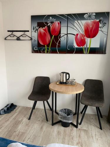 a table and two chairs in a room with a painting at Amsterdam Soul Inn in Amsterdam