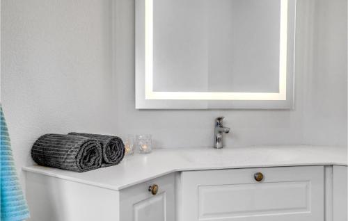 a bathroom with a white sink and a mirror at Awesome Home In Blåvand With Sauna in Blåvand